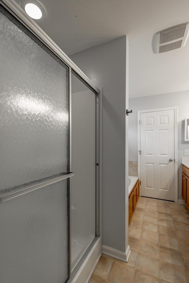 bathroom with tile patterned floors, vanity, and plus walk in shower