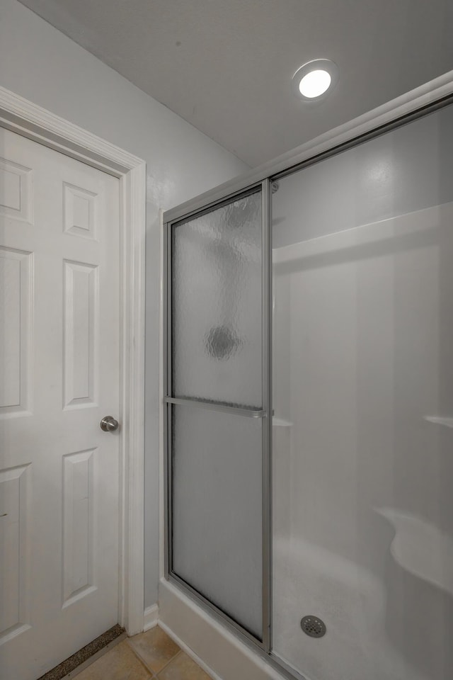 bathroom with tile patterned floors and walk in shower