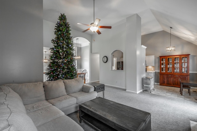 living room with ceiling fan with notable chandelier, light colored carpet, and high vaulted ceiling