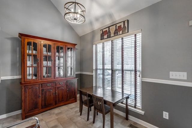 dining space with vaulted ceiling and a notable chandelier