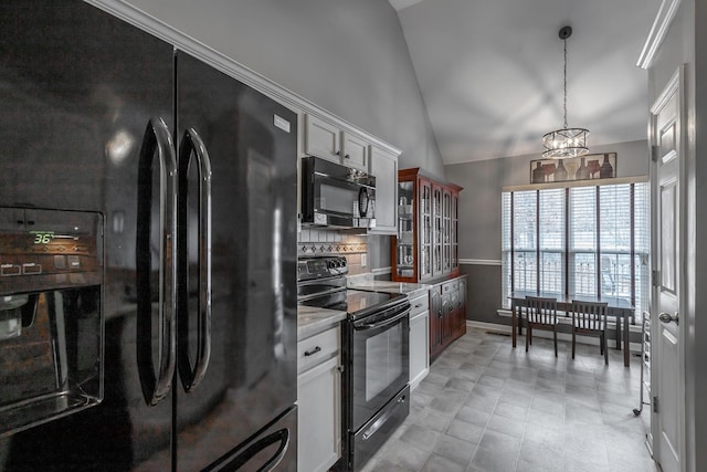 kitchen with tasteful backsplash, pendant lighting, vaulted ceiling, white cabinets, and black appliances