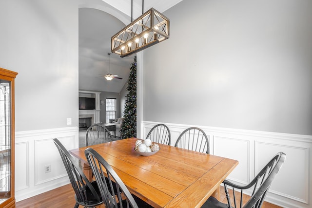 dining area featuring ceiling fan, vaulted ceiling, and hardwood / wood-style flooring