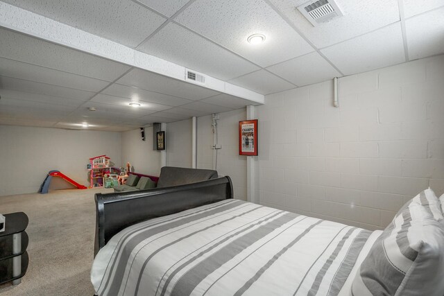 bedroom with carpet flooring and a paneled ceiling