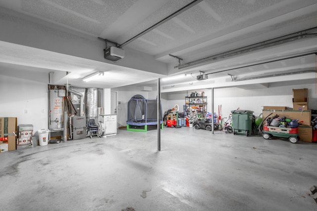 garage with a garage door opener, gas water heater, and a trampoline