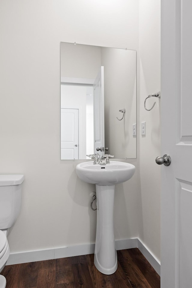 bathroom featuring hardwood / wood-style flooring and toilet