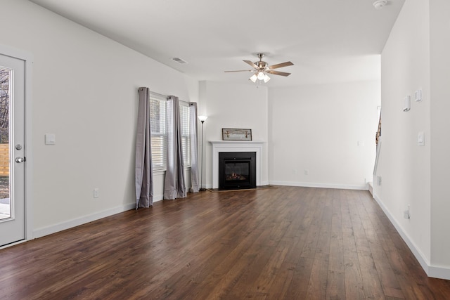 unfurnished living room featuring ceiling fan and dark hardwood / wood-style floors