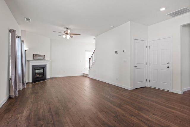 unfurnished living room with ceiling fan and dark wood-type flooring