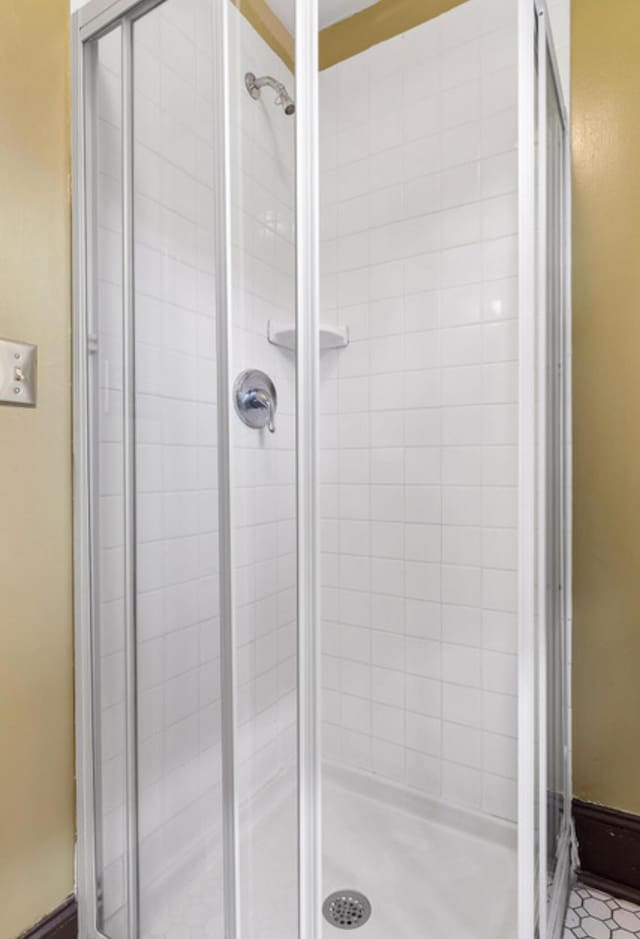 bathroom with tile patterned floors and a shower with door