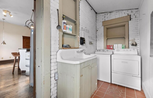 bathroom with tile patterned floors, brick wall, sink, independent washer and dryer, and lofted ceiling