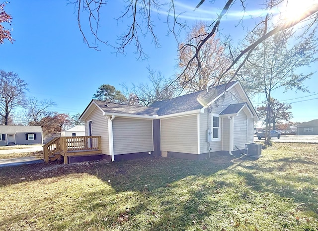 view of home's exterior with a yard, cooling unit, and a wooden deck