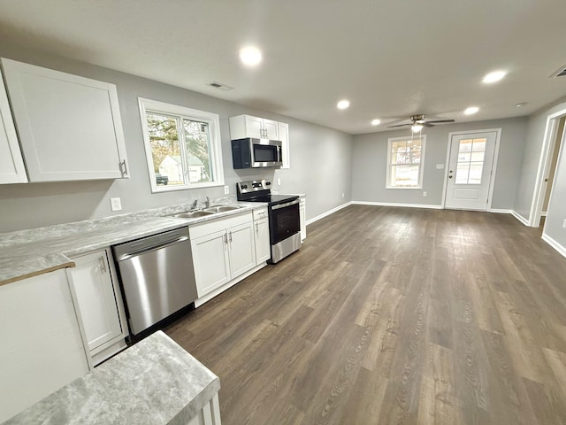 kitchen featuring a wealth of natural light, white cabinetry, sink, and appliances with stainless steel finishes