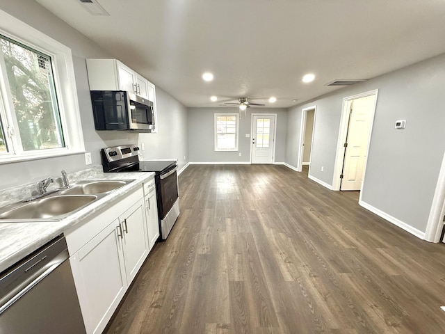 kitchen featuring appliances with stainless steel finishes, ceiling fan, dark wood-type flooring, sink, and white cabinetry