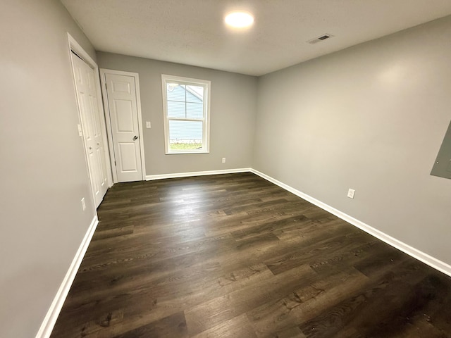 unfurnished room with dark hardwood / wood-style flooring