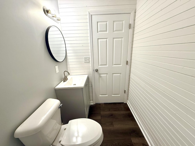 bathroom featuring toilet, vanity, and hardwood / wood-style flooring