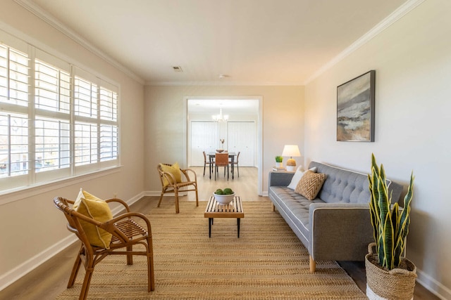 sitting room featuring light hardwood / wood-style floors, crown molding, and a notable chandelier