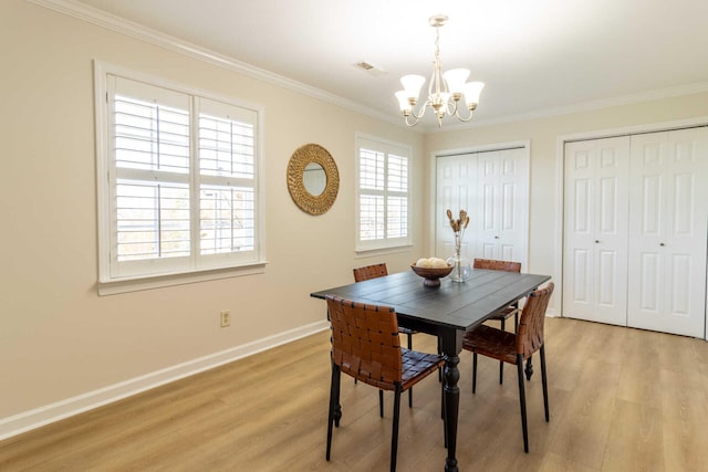 dining area with a chandelier, light hardwood / wood-style floors, and ornamental molding