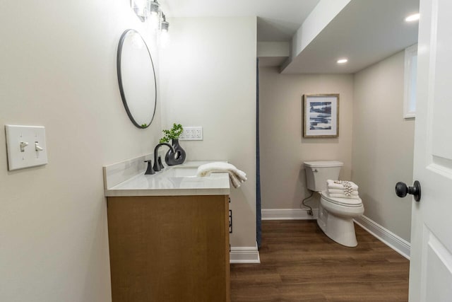 bathroom with vanity, toilet, and wood-type flooring