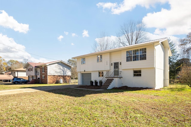 rear view of property with a lawn and a garage