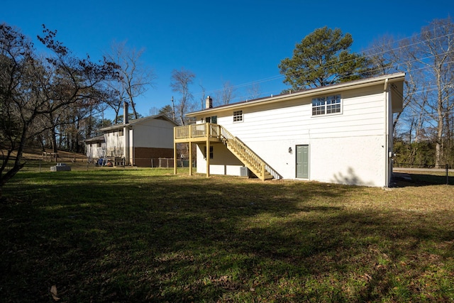 rear view of house with a lawn and a deck