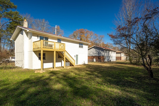 rear view of property with central air condition unit, a wooden deck, and a yard