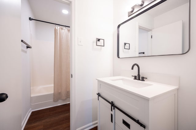 bathroom with vanity, hardwood / wood-style flooring, and shower / bath combo with shower curtain