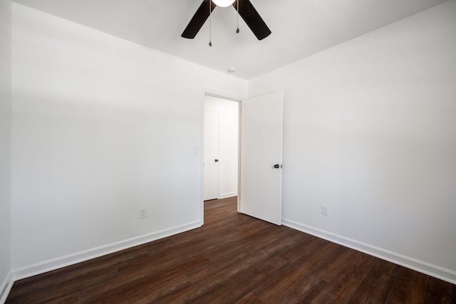 empty room with dark hardwood / wood-style floors and ceiling fan