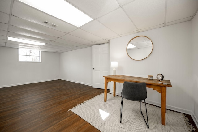 home office with a paneled ceiling and dark hardwood / wood-style floors