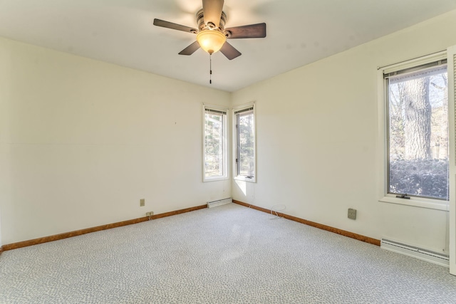 carpeted spare room with a baseboard radiator and ceiling fan