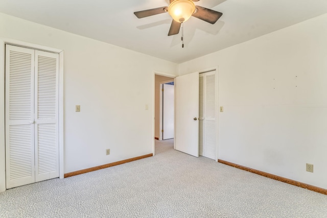 unfurnished bedroom featuring ceiling fan, light carpet, and two closets