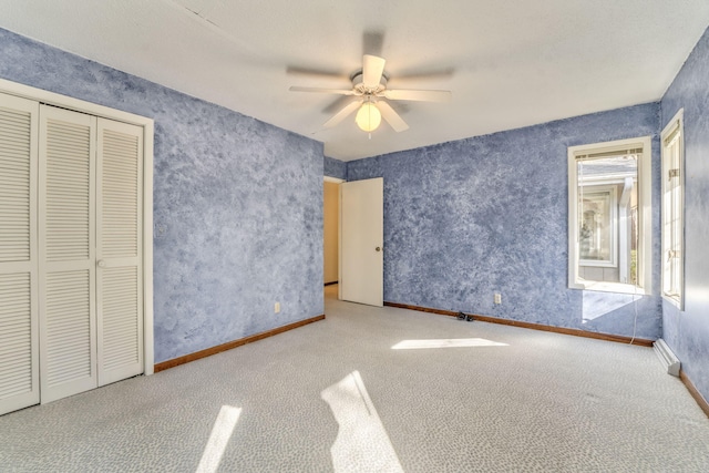 unfurnished bedroom featuring a closet, ceiling fan, and light colored carpet