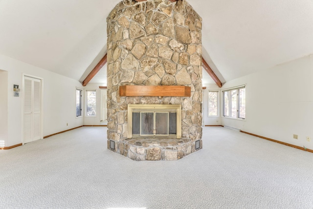 unfurnished living room featuring light carpet, vaulted ceiling with beams, a stone fireplace, and a wealth of natural light