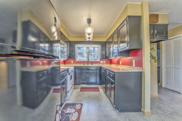 kitchen featuring sink, pendant lighting, a textured ceiling, stainless steel electric range, and fridge