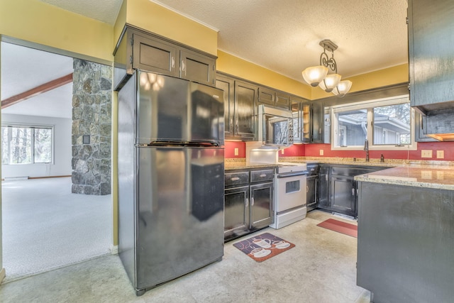 kitchen with light carpet, refrigerator, white range, and hanging light fixtures