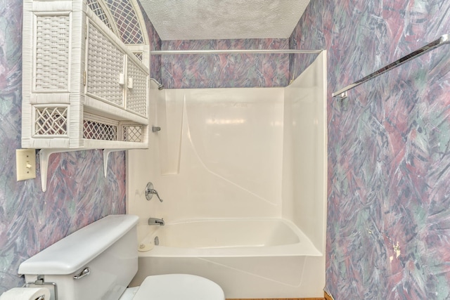 bathroom featuring shower / bathtub combination, toilet, and a textured ceiling