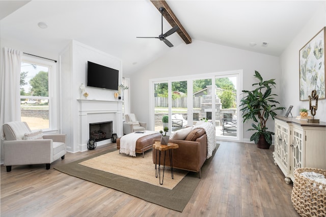 living room with ceiling fan, hardwood / wood-style floors, and lofted ceiling with beams