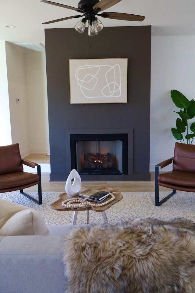 living room featuring ceiling fan and hardwood / wood-style floors