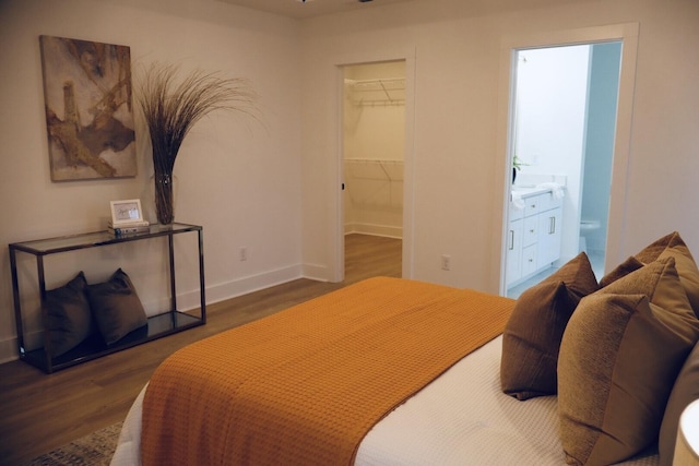 bedroom featuring ensuite bath, a closet, a spacious closet, and dark hardwood / wood-style flooring