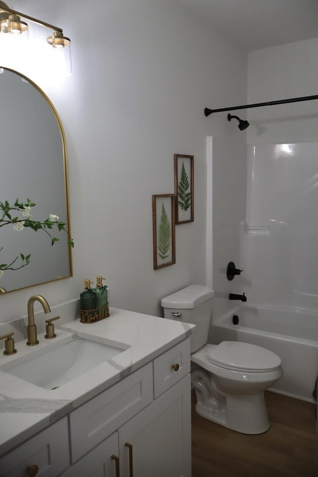 full bathroom with shower / bathing tub combination, wood-type flooring, vanity, and toilet