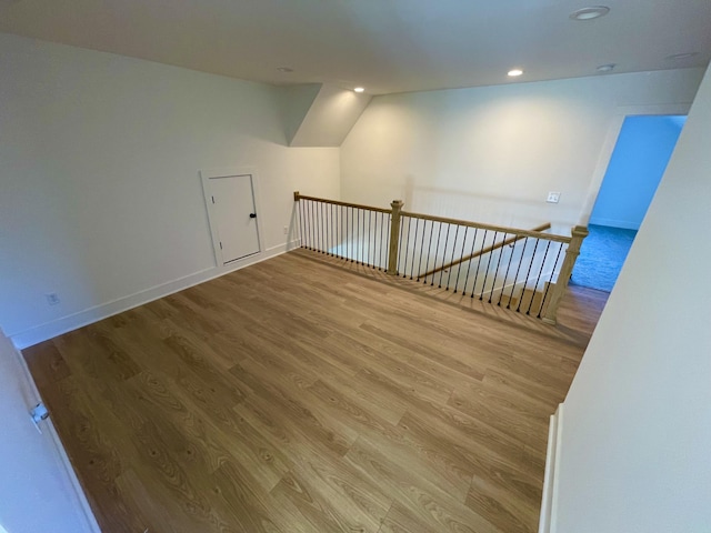 spare room featuring vaulted ceiling and wood-type flooring