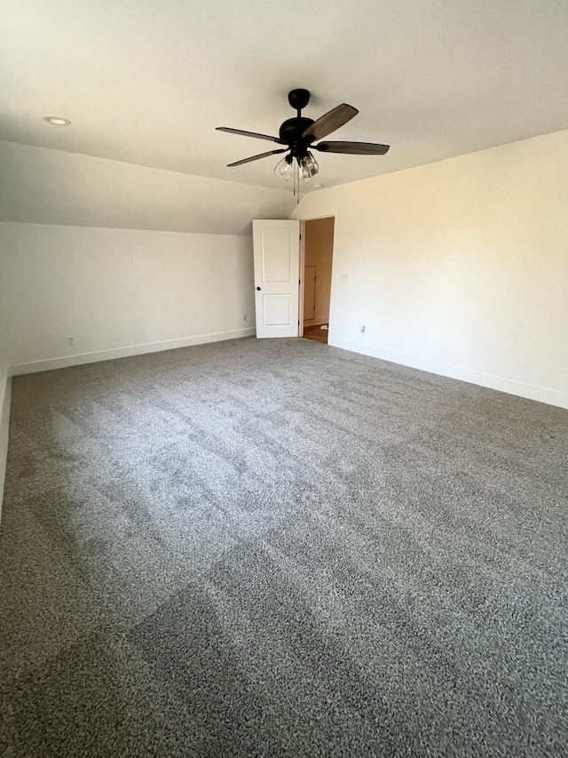 spare room featuring carpet floors, ceiling fan, and vaulted ceiling