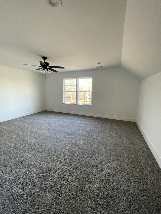 carpeted spare room with ceiling fan and vaulted ceiling