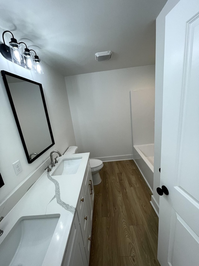 bathroom featuring toilet, vanity, and wood-type flooring