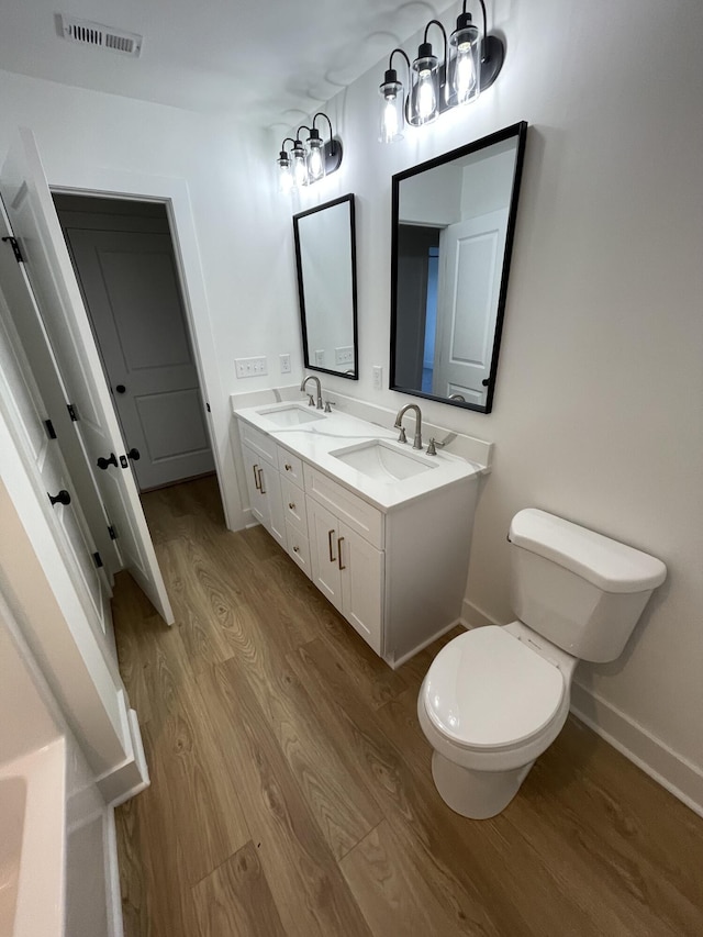 bathroom featuring hardwood / wood-style floors, vanity, and toilet