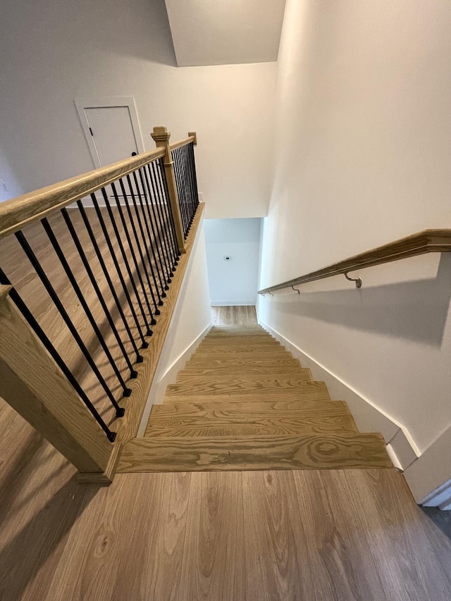 staircase with hardwood / wood-style flooring