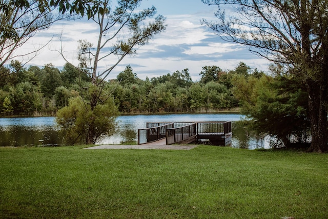 dock area with a yard and a water view