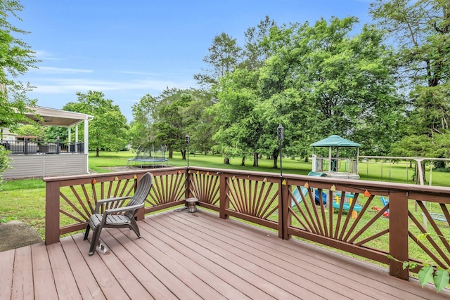 wooden terrace featuring a gazebo, a trampoline, and a lawn