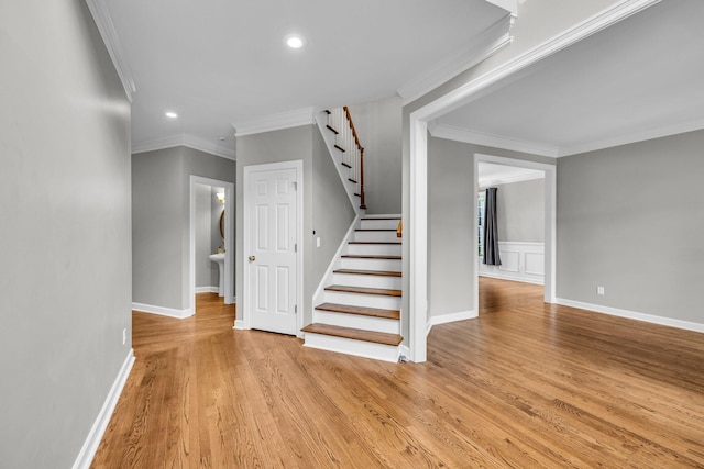 stairs featuring crown molding and hardwood / wood-style flooring