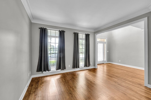 spare room featuring light hardwood / wood-style floors and ornamental molding