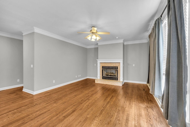 unfurnished living room featuring a wealth of natural light, a fireplace, ornamental molding, and hardwood / wood-style flooring