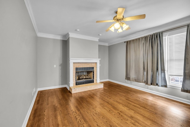 unfurnished living room featuring a fireplace, wood-type flooring, ceiling fan, and crown molding